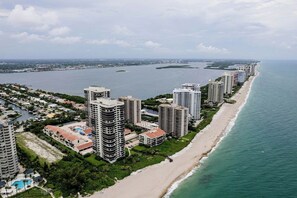 A coastal residential area with high-rise buildings, a beach, and a marina. - Singer Island Serenity (West Palm Beach)