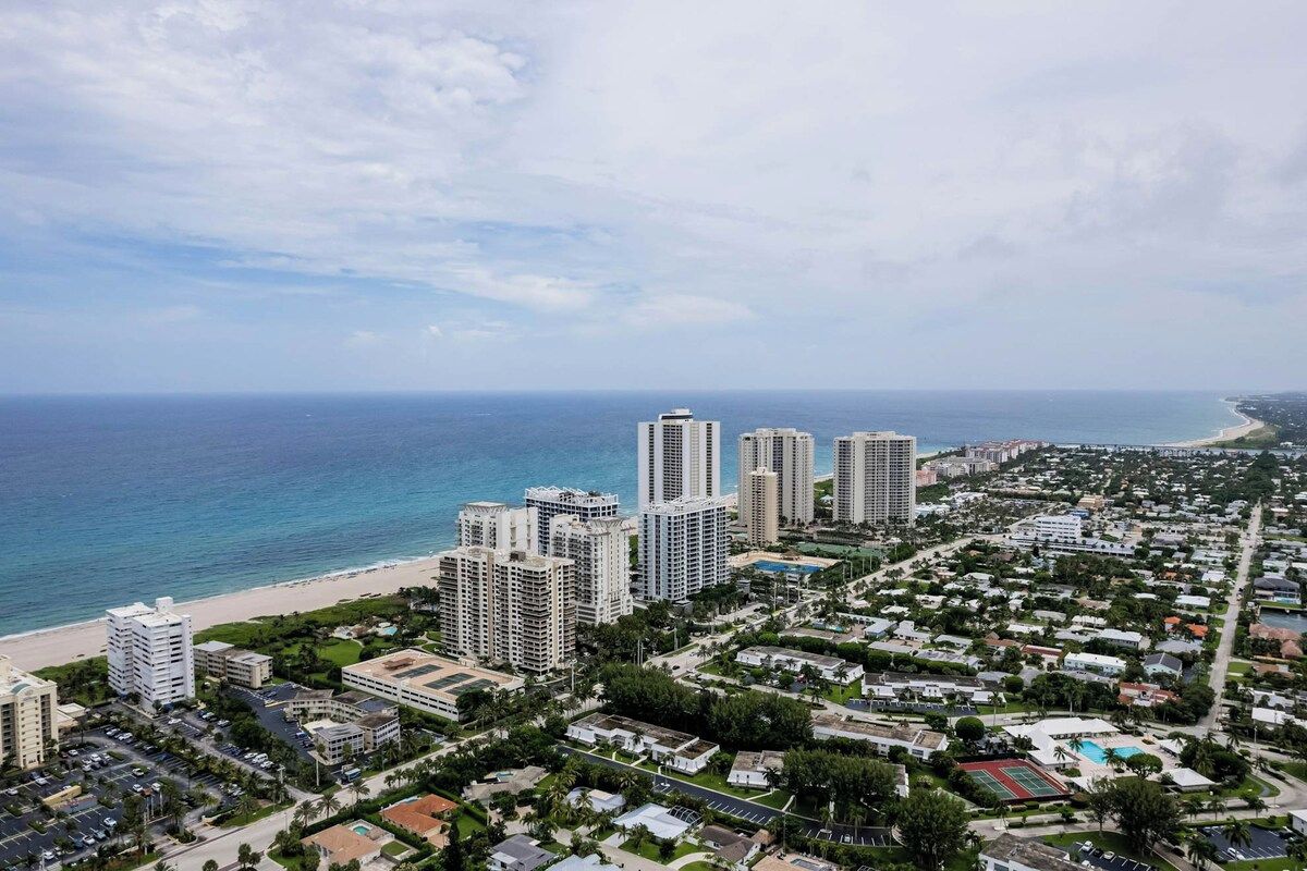 Un paysage urbain côtier avec de hauts immeubles, une plage et un quartier résidentiel.