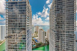 A high-rise building with a view of a body of water and other buildings in the background. - Iconic Views - Luxury Condo in the Heart of Brickell (Miami)
