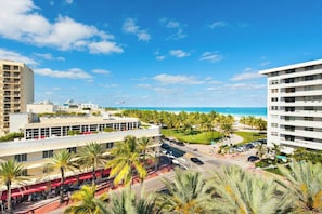 A coastal hotel with multiple floors, a parking area, and a view of the beach. - Modern Ocean Drive Condo in the Heart of Sobe (Miami Beach)