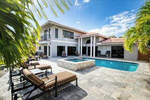 A two-story house with a swimming pool, outdoor seating, and a covered patio area. - Rustling Palms - Private Pool (Fort Lauderdale)