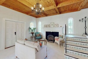 A spacious living room with a fireplace, a staircase with decorative railings, and a chandelier. - Villa Sunset - Private Pool (West Palm Beach)
