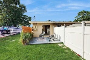 A residential property with a fenced backyard, a patio with outdoor furniture, and a visible garage door. - The Palms Unit 2 - Enclosed Yard (Fort Lauderdale)