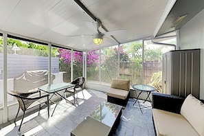 A covered outdoor patio with a glass table, chairs, and a sofa. - Designer Delight - Private Pool (Wilton Manors)
