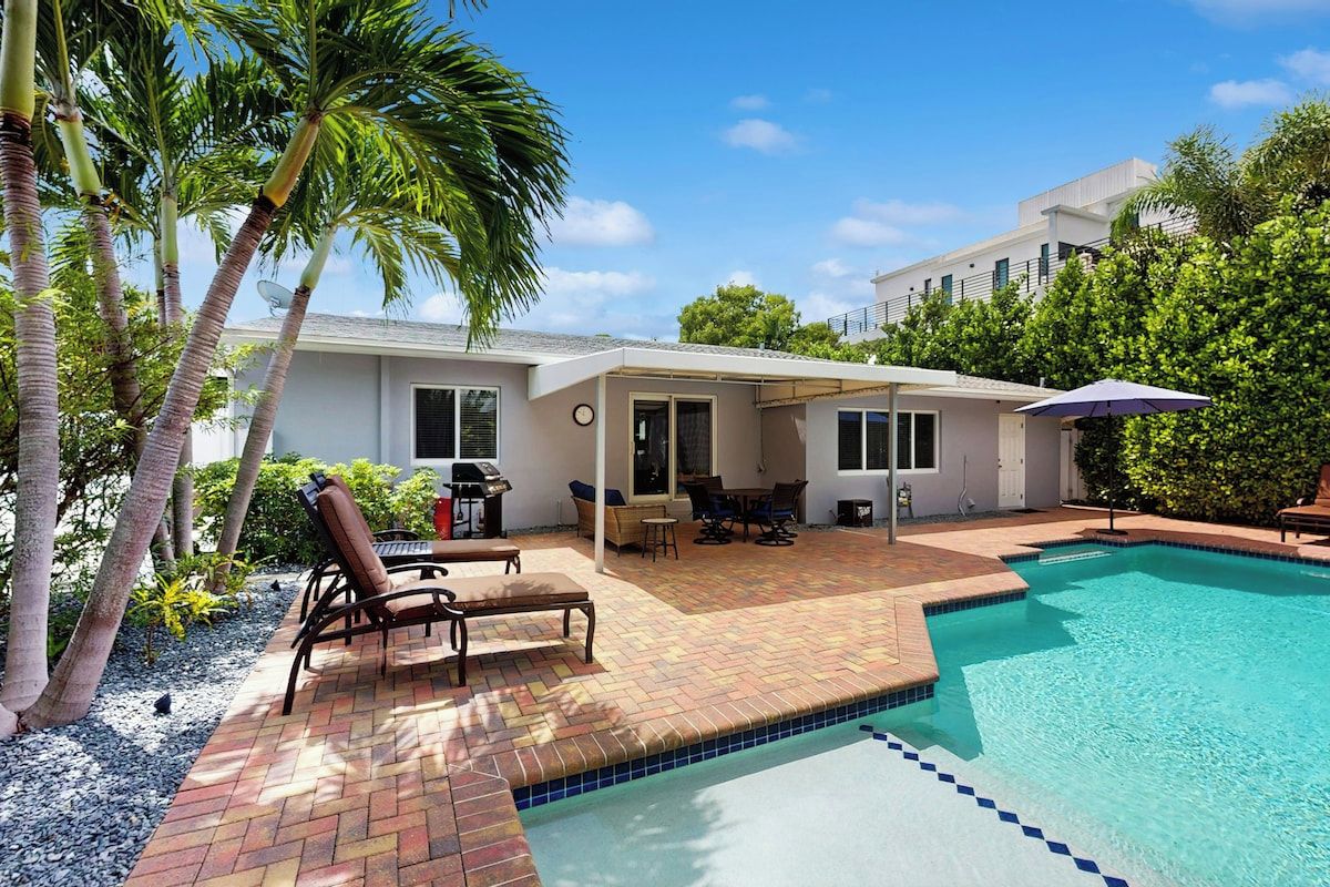 A residential property with a swimming pool, patio furniture, and a satellite dish.