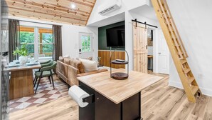 A modern interior with a wooden ceiling, a dining area, a sofa, and a TV. - Newly built private cabin with fire pit, Sauna. Close to National park entrance (Fort Valley)