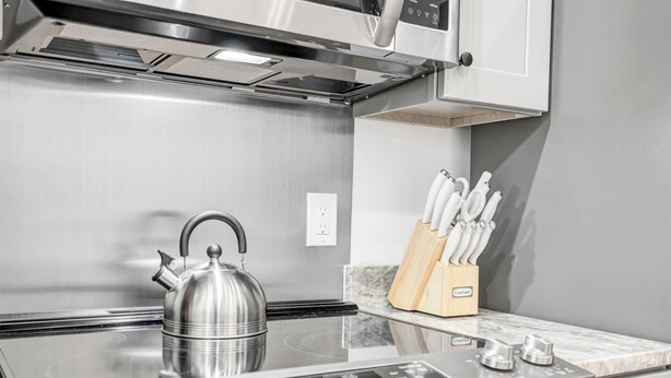 A modern kitchen with a stainless steel kettle, a knife block, and a built-in induction cooktop. - Newly built private cabin with fire pit, Sauna. Close to National park entrance (Fort Valley)