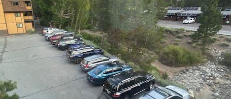 A parking lot with multiple cars and a building with a sloped roof.