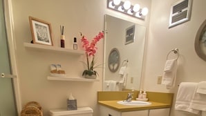 Ein Badezimmer mit Toilette, Waschbecken, Spiegel und Waschtisch.