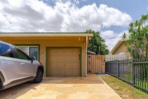 A residential property with a garage, a paved driveway, and a fenced yard.
