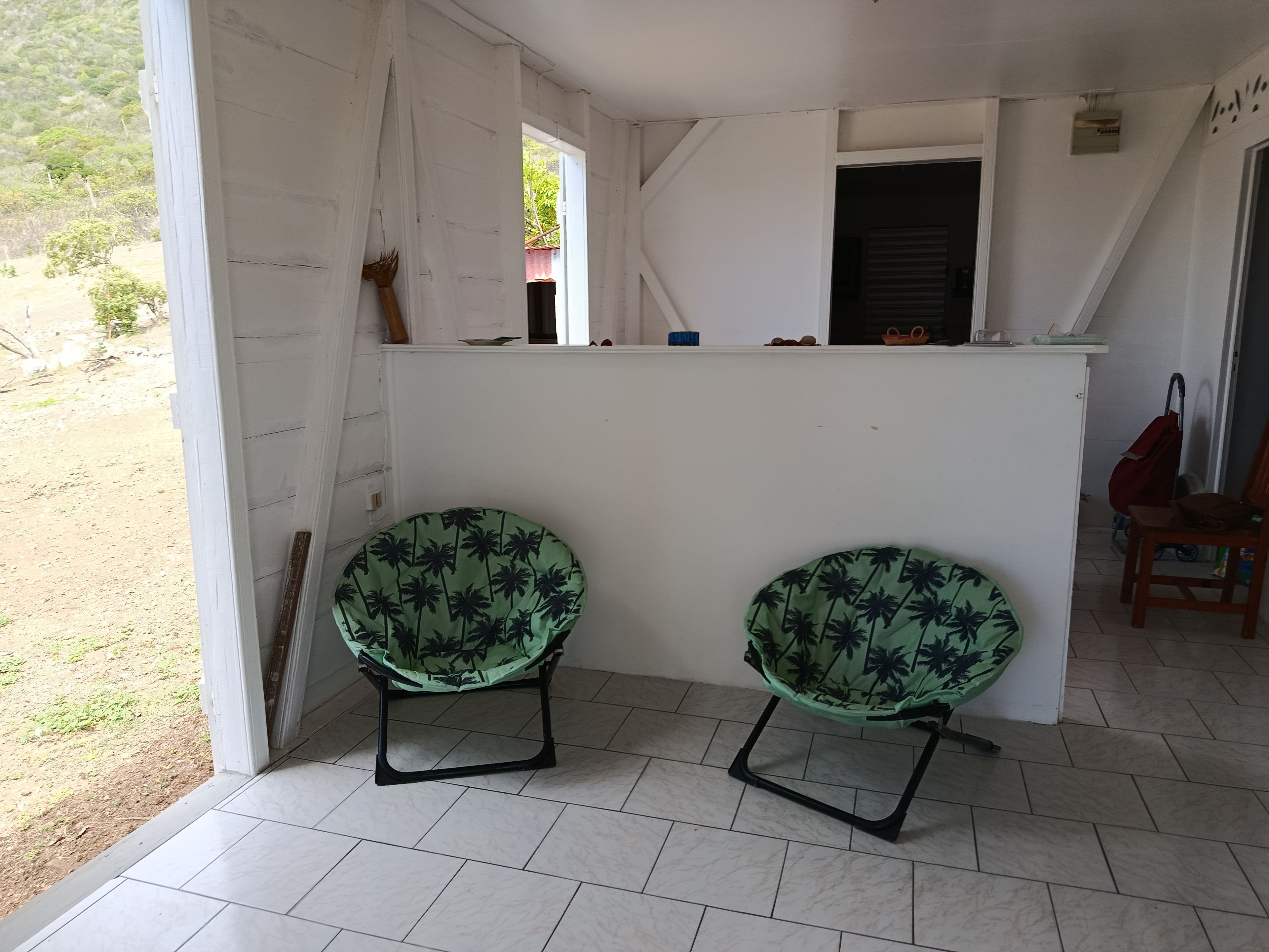 Una habitación con dos sillas, una pequeña zona de bar y vistas al exterior.
