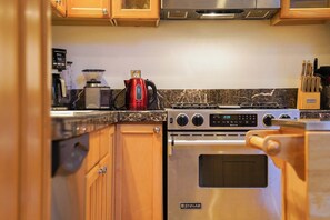 A kitchen with a Jenn-Air oven, a red coffee maker, and a stove. - Mt Baker Snowline Chalet | Private Hot Tub + Fireplace | Sleeps 6 (Deming)