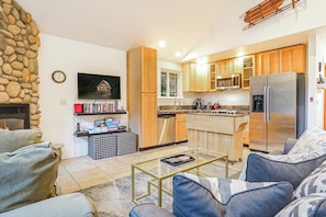 A modern kitchen with wooden cabinets, a stainless steel refrigerator, and a microwave.