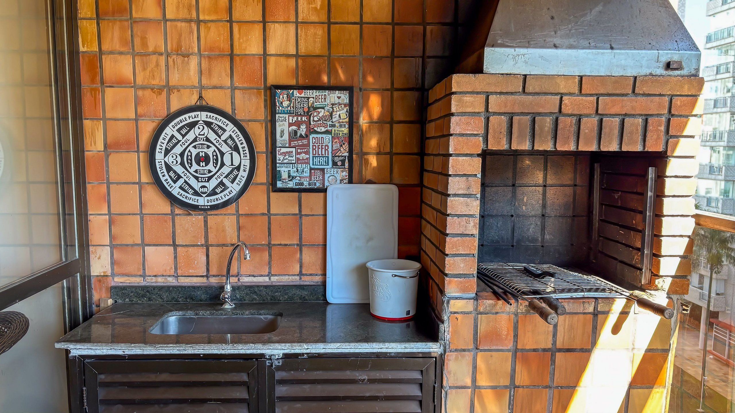 Una cocina con horno de ladrillo, un lavabo y un reloj en la pared.