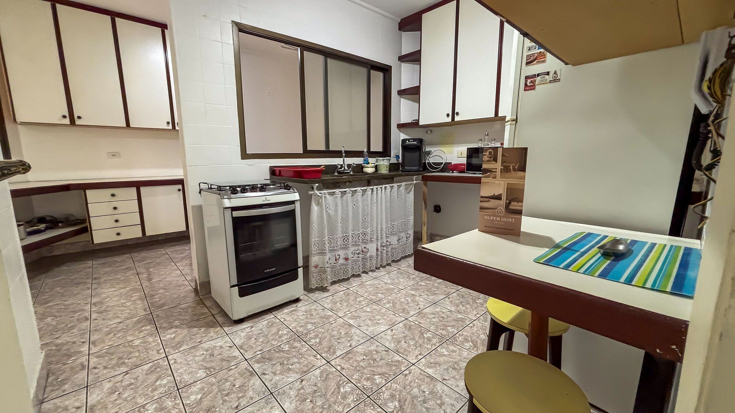 Une cuisine compacte équipée d’une cuisinière, d’un four et d’un petit coin repas avec une table et des chaises.