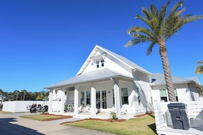 A two-story house with a gabled roof, a covered porch, and a palm tree. - Most Kid-Friendly 30A Home + Private Heated Pool + Golf Cart + All Beach Gear (Inlet Beach)