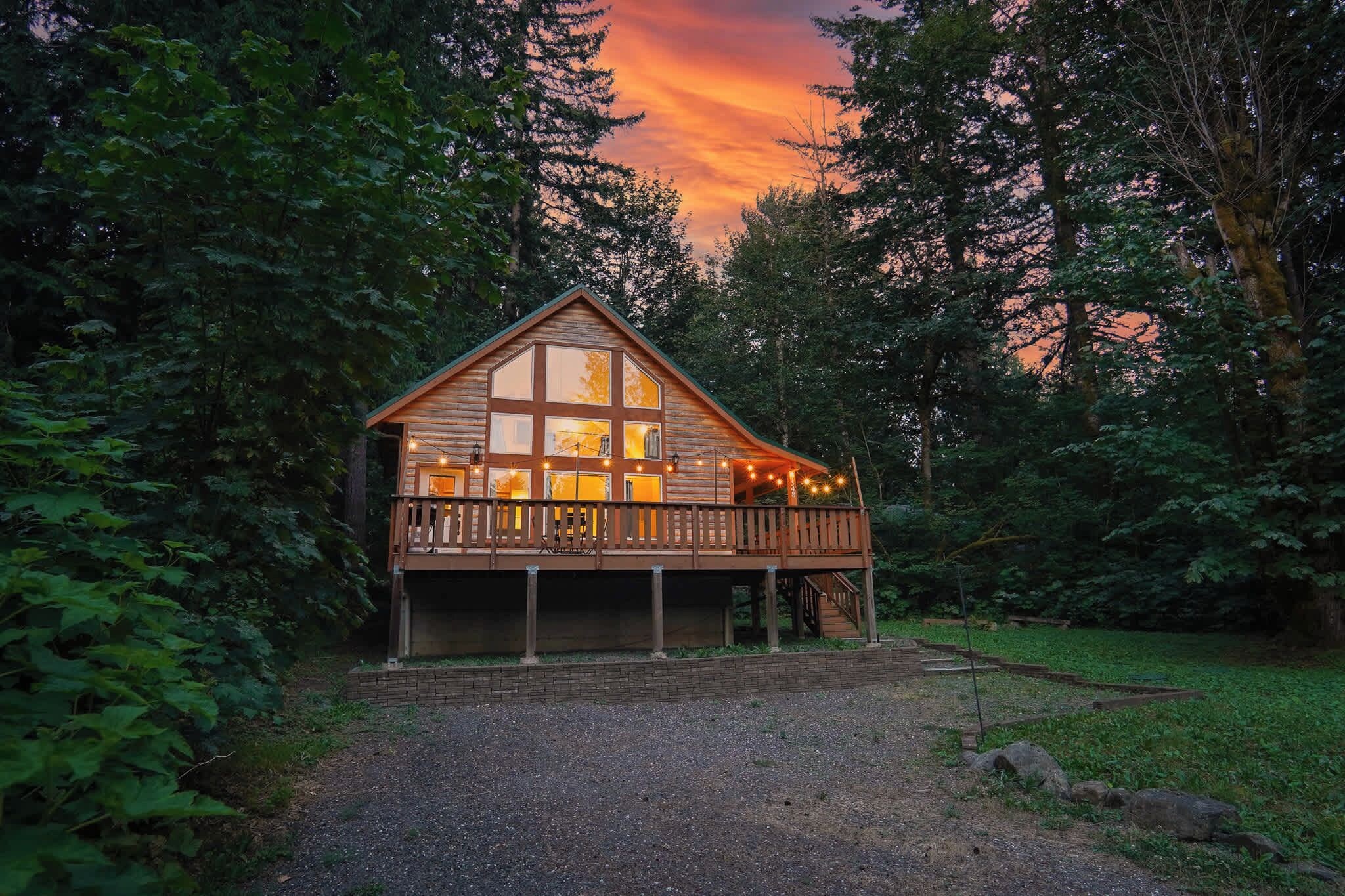 Une cabane en bois dotée d’un balcon, entourée d’arbres.
