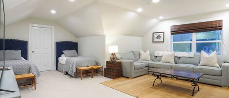 A bedroom with a bed, bedside table, lamp, and a window with blinds.