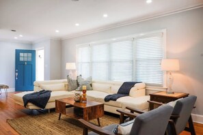 Ein Wohnzimmer mit einer Couch, einem Couchtisch und Lampen.