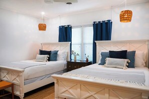 A double room with two beds, a window with curtains, and hanging lamps. - Parkside Retreat | Walk to St. Simons Village, Pier & Park | Pet Friendly (St. Simons Island)