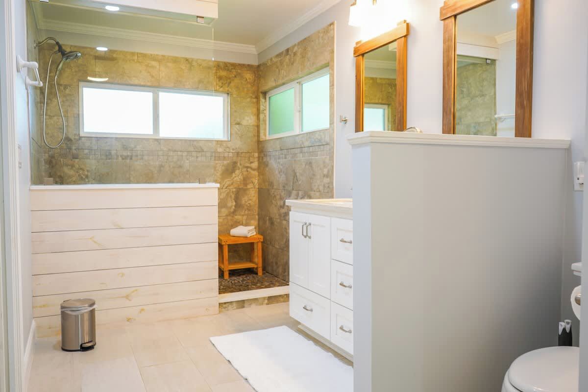 A bathroom with a shower, a toilet, and a sink.