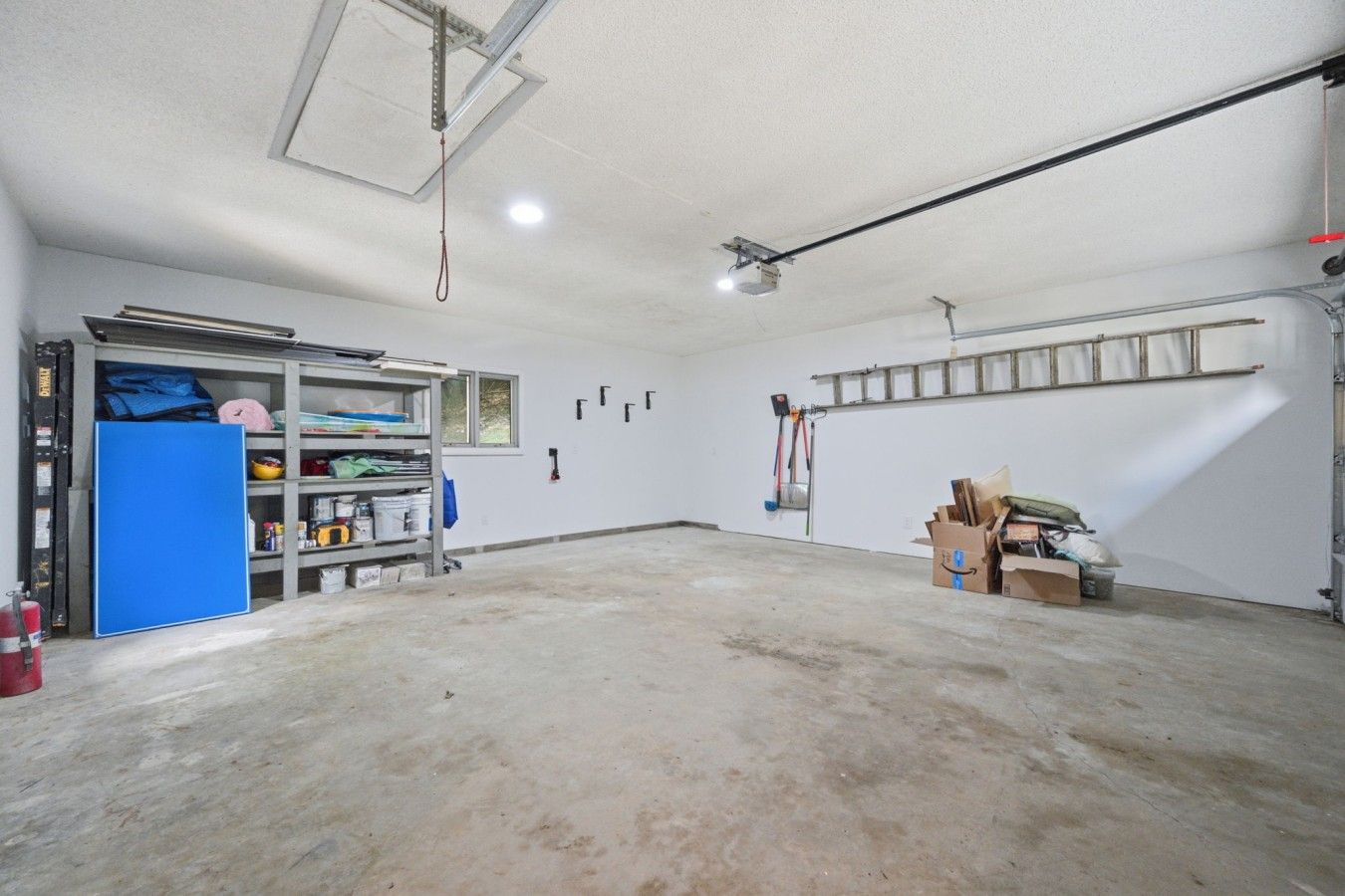 A spacious garage with a workbench, shelving, and various tools.