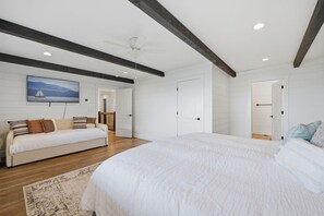 A bedroom with a large bed, a sofa, and a ceiling fan. - Yuppie Buck |  2mi to Ski Resort, Stunning Views & Game Room (Beech Mountain)