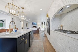 A modern kitchen with a large island, built-in appliances, and a fireplace. - Yuppie Buck |  2mi to Ski Resort, Stunning Views & Game Room (Beech Mountain)