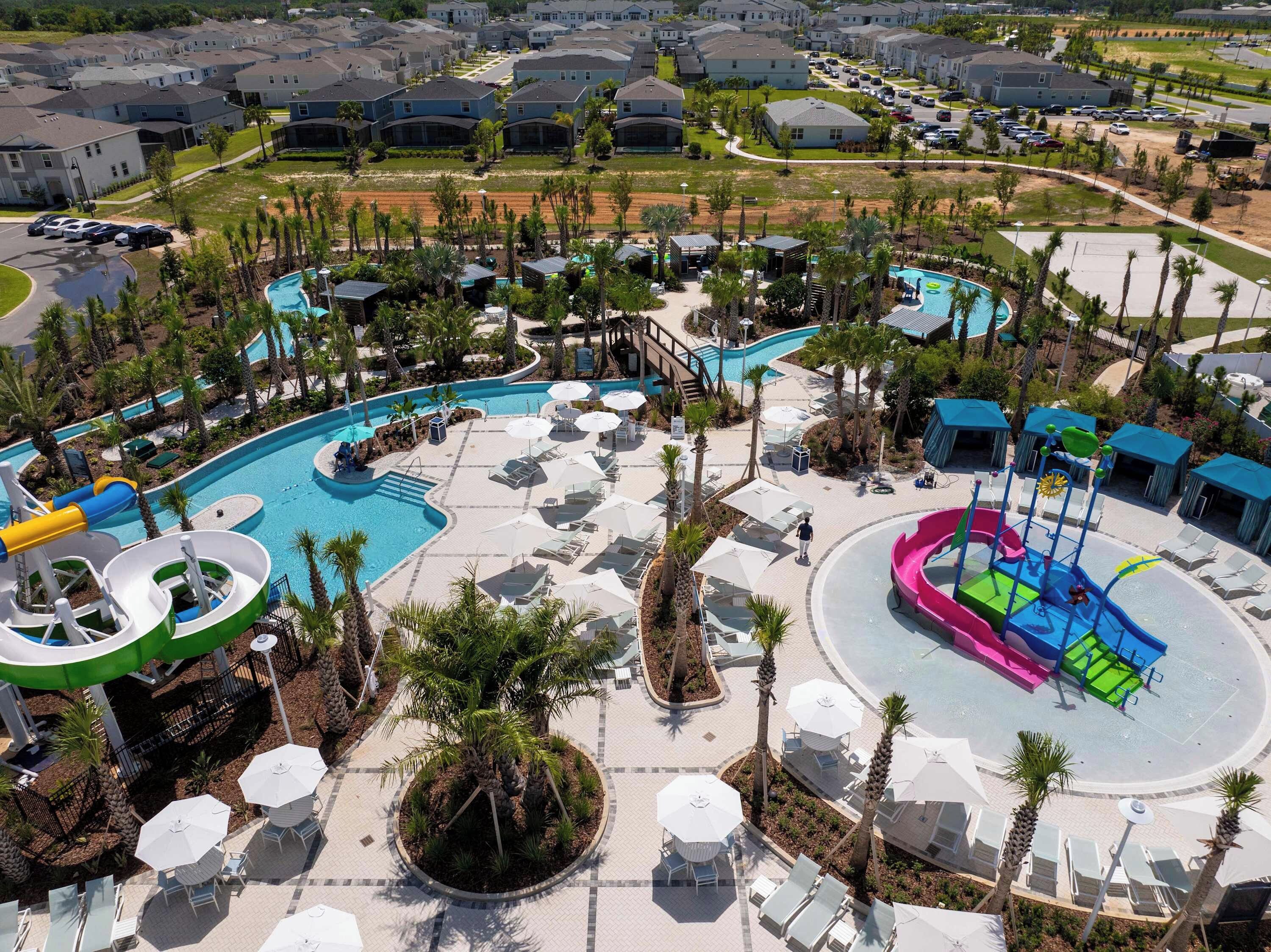 A resort with a large pool area, water slides, and lounge chairs.