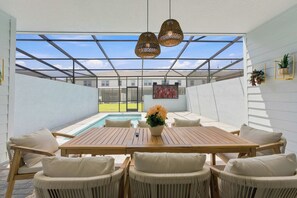 A sunlit patio with a pool, outdoor seating, and a clear view of the neighborhood. - 16217 Toy Story & Mickey Rooms! Windsor Cay 5BR (Clermont)