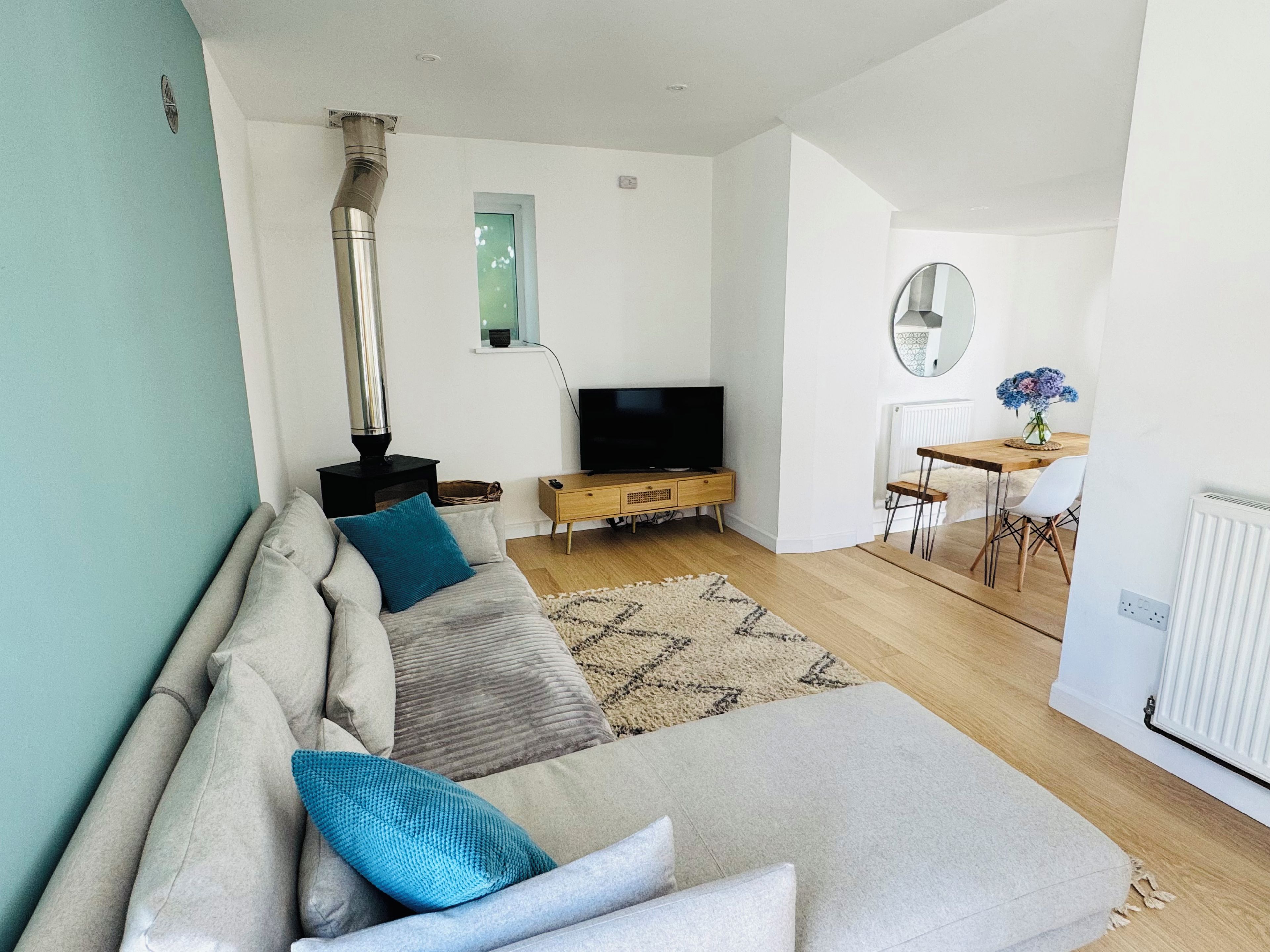 A modern living room with a sofa, television, and a fireplace.