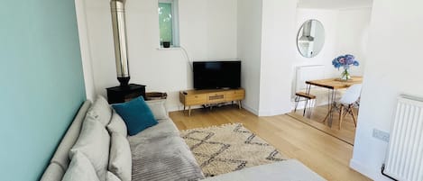 A modern living room with a sofa, television, and a fireplace.