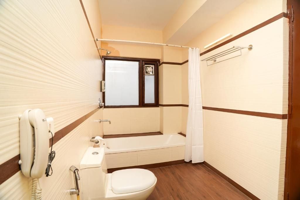 Un baño pequeño con inodoro, bañera y cabina de ducha.