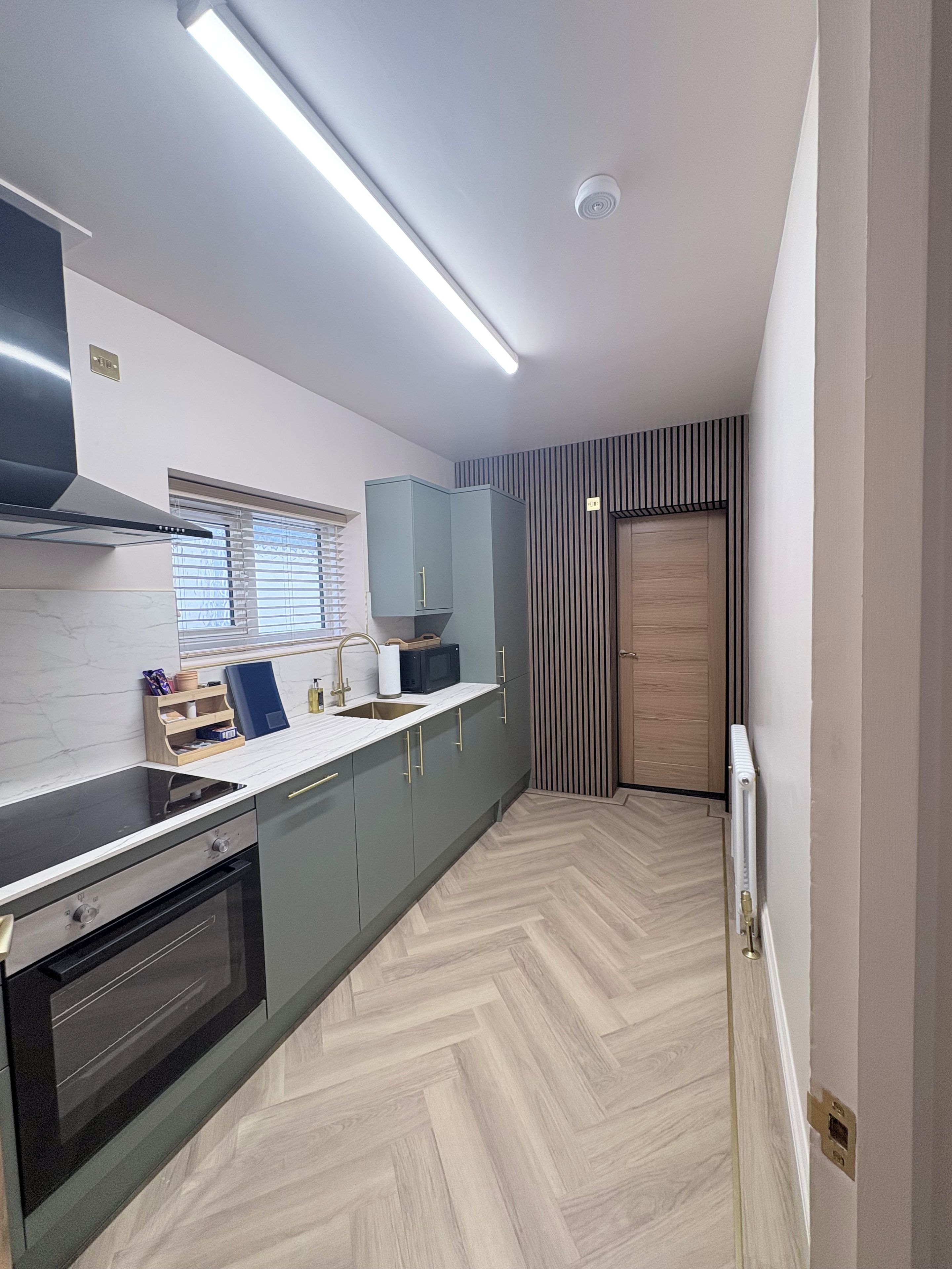 A modern kitchen with a built-in oven, a microwave, and a sink.