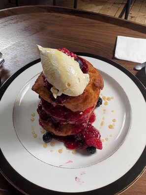 Un dessert composé de crème glacée et de fruits rouges, présenté dans une assiette.