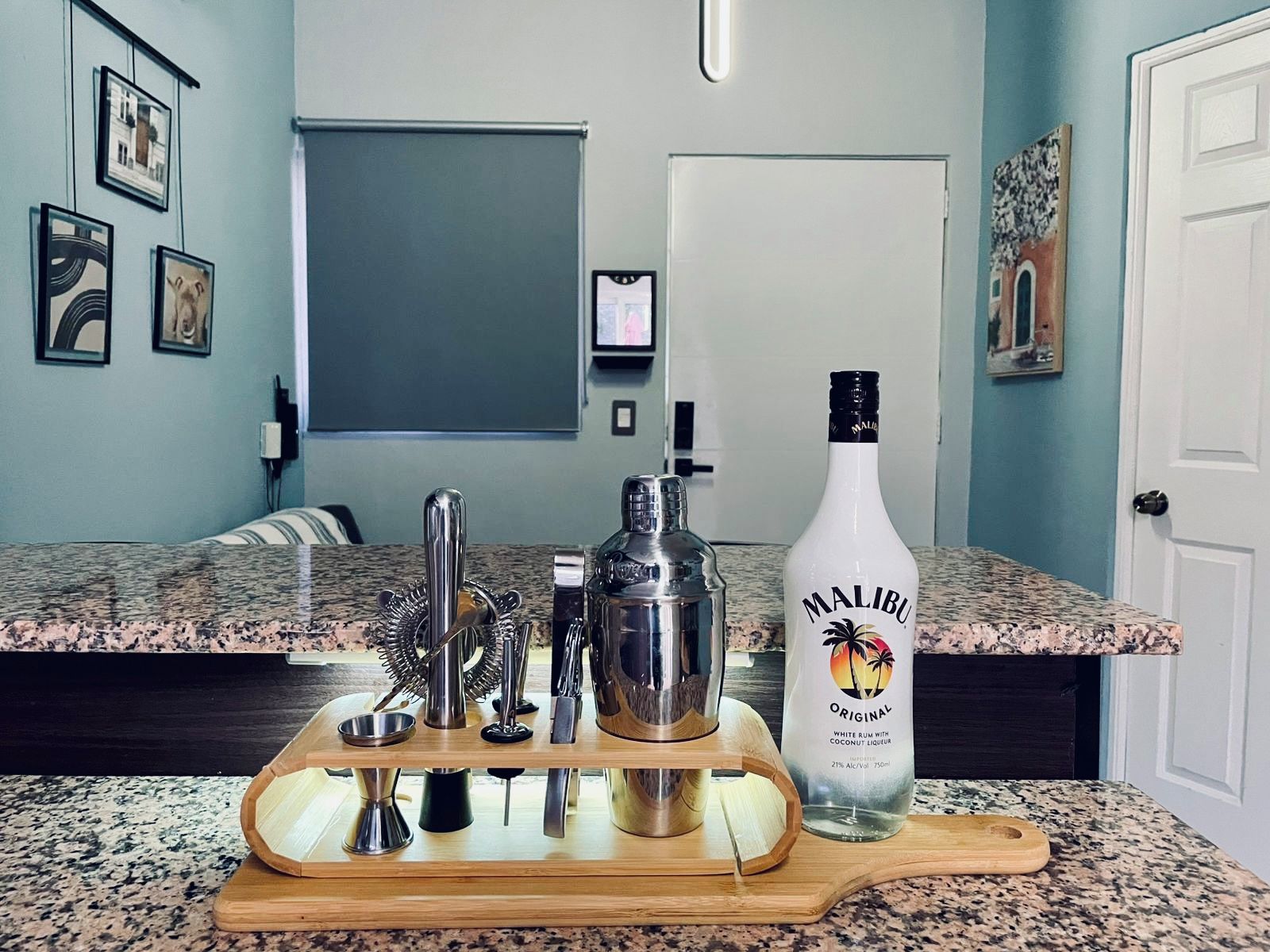 En köksbänk med en flaska Malibu Original-rom, en cocktailshaker och olika bartillbehör.