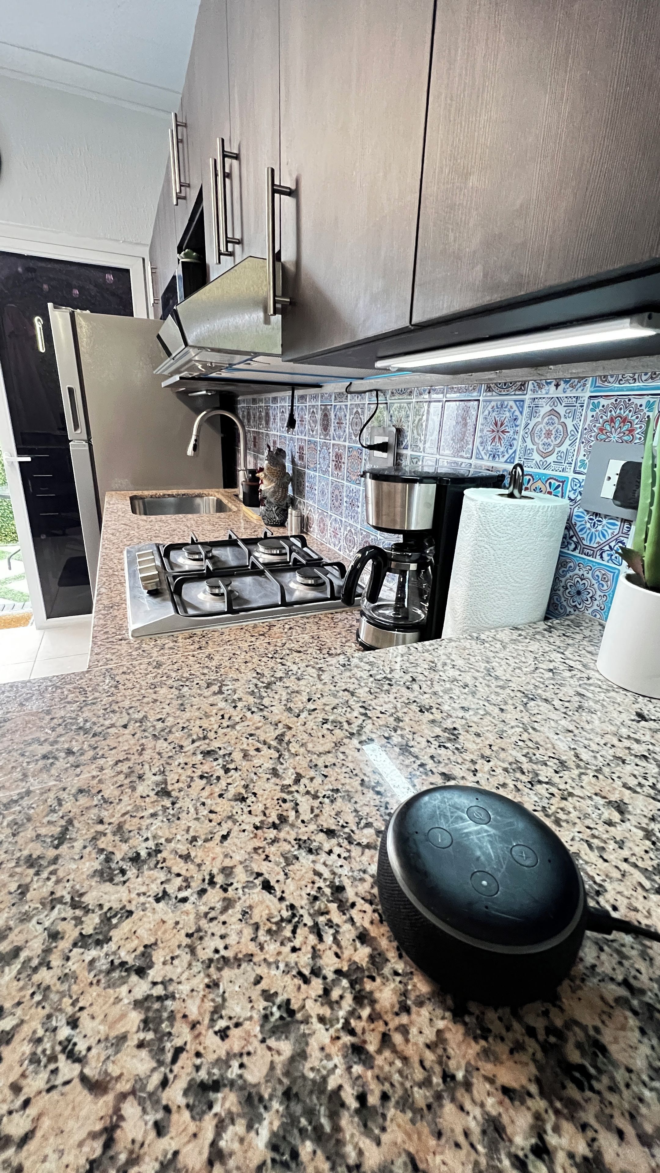 Et køkken med granitbordplader, rustfrie stålapparater og et backsplash med mønstret flis.