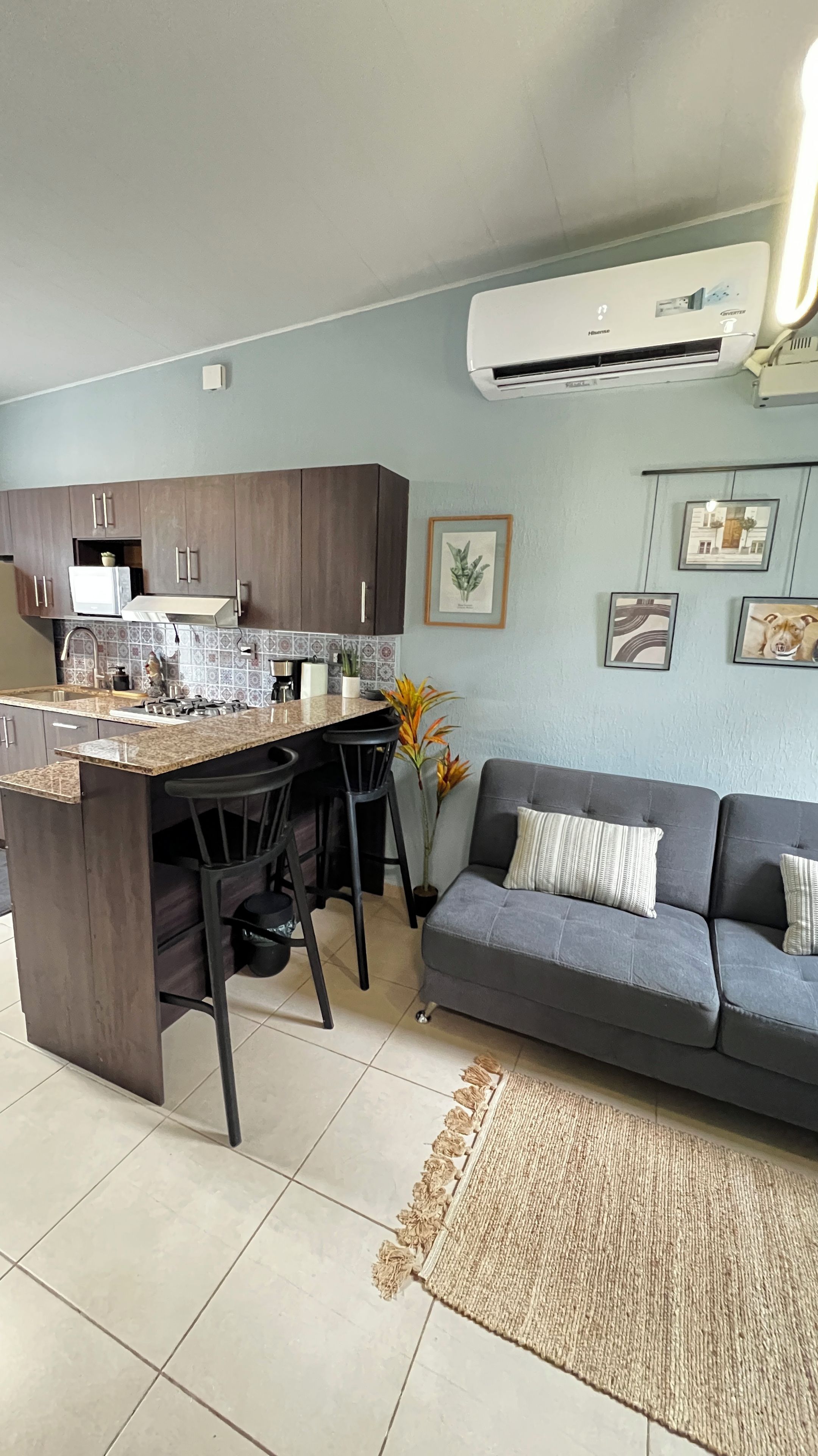 Een compacte wooneenheid met een kitchenette, een eethoek en een zithoek.