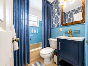 Ein Badezimmer mit Badewanne, Toilette und Waschtisch.