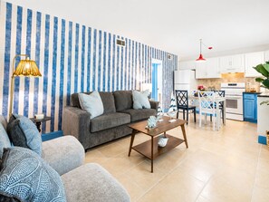 Ein modernes Wohnzimmer mit einer Couch, einem Couchtisch und einem Essbereich mit Tisch und Stühlen.