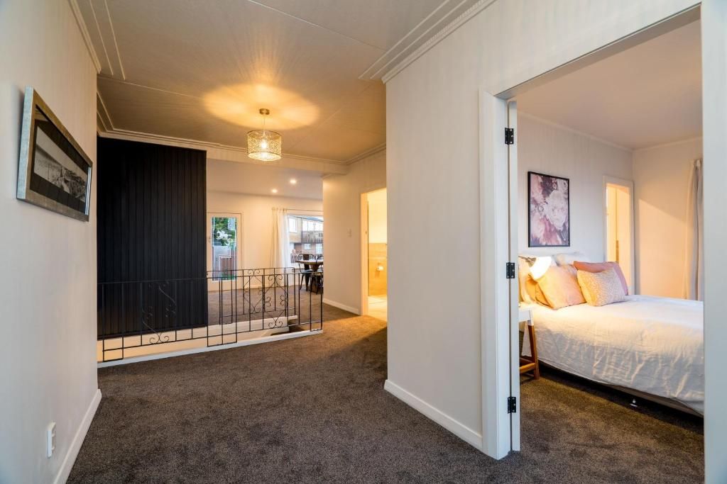 A bedroom with a bed, a nightstand, and a wall-mounted lamp.