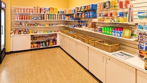 L’intérieur d’une épicerie, avec des étagères remplies de divers produits alimentaires et des paniers.