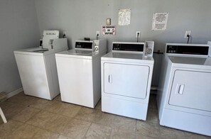A laundry room with four white washing machines and a no smoking or vaping sign on the wall. - Beautiful 1-bedroom condo in beach town Wells with an indoor pool (Wells)