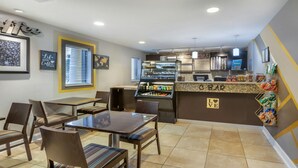 Ein Café mit Theke, Sitzgelegenheiten und einer Kaffeemaschine.