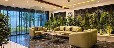 A modern living room with leather sofas, a coffee table, and a ceiling fan.