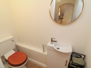 A bathroom with a toilet, sink, and mirror. - No.40 Rufford Road (Nottingham)