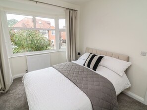 A bedroom with a bed, a window, and a radiator. - No.40 Rufford Road (Nottingham)