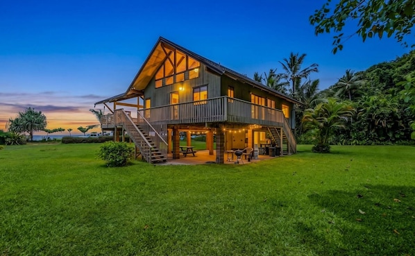 A two-story house with a balcony, a deck, and a patio area.