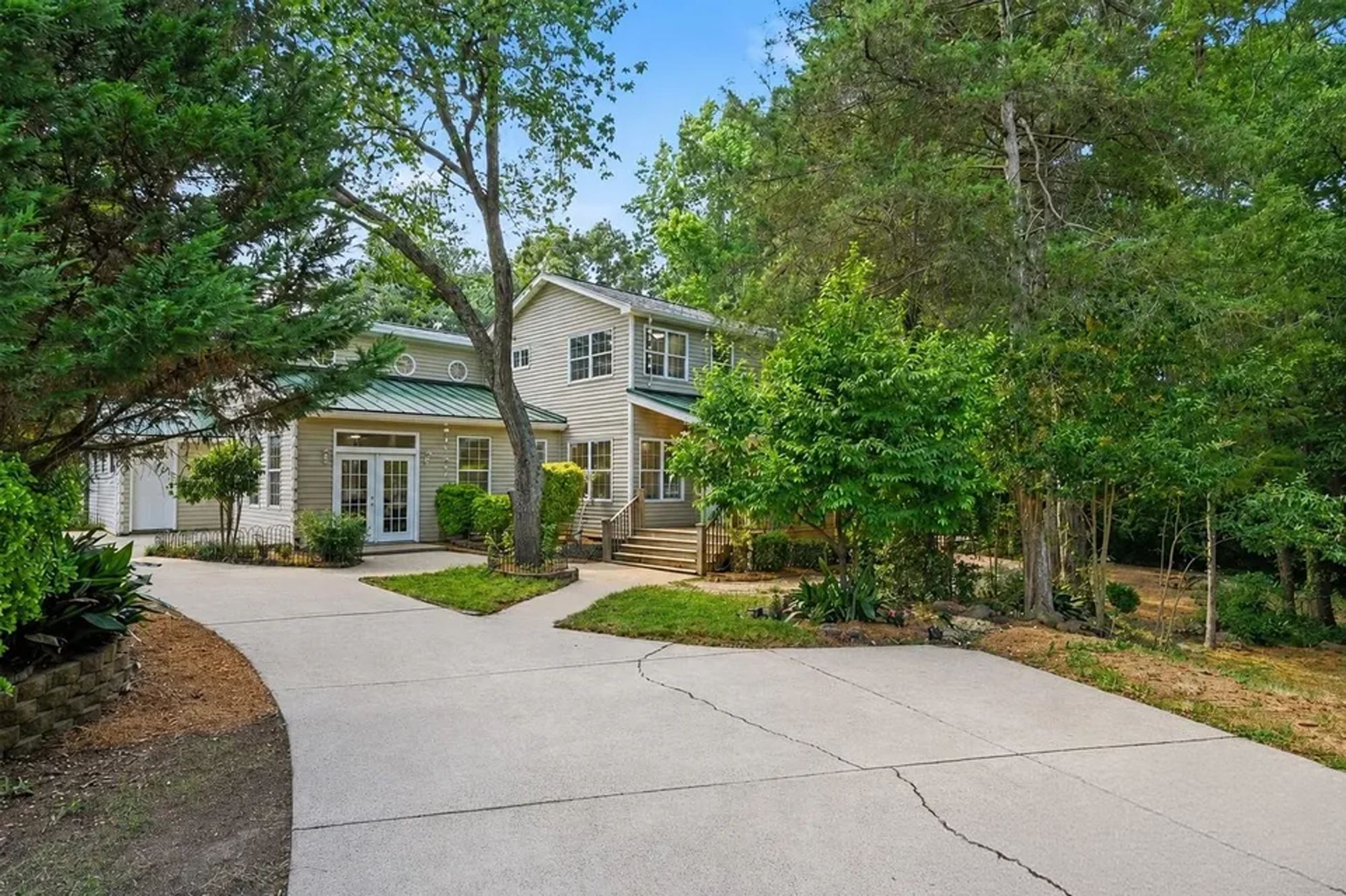 A two-story house with a front yard and a driveway.