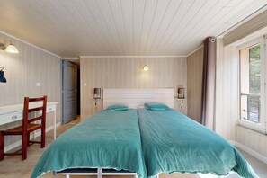 Une chambre avec deux lits, un bureau et une chaise.